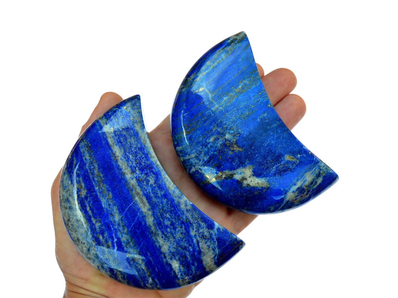 hree large lapis lazuli moon carving crystals 95mm on hand with white background