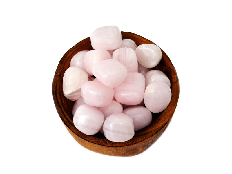 Several pink mangano calcite tumbled crystals inside a wood bowl