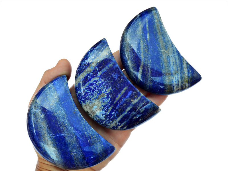 Three big lapis lazuli moon carving crystals 90mm on hand with white background