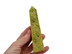 One large green serpentine obelisk mineral 100mm on hand with white background