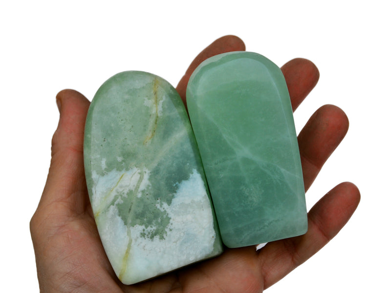 Two pistachio calcite free forms 85mm-90mm on hand with white background