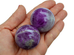 Two amethyst sphere crystals 45mm on hand with white background