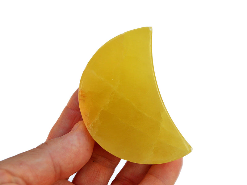 One lemon calcite moon mineral 65mm on hand with white background