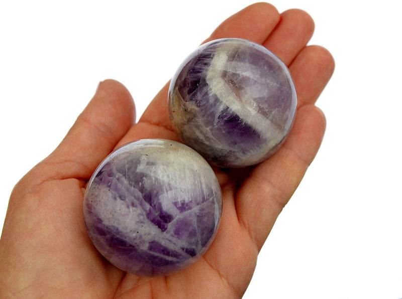Two amethyst sphere stones 45mm-50mm on hand with white background