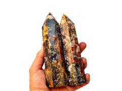 Two multicolor ocean jasper points 130mm on hand with white background