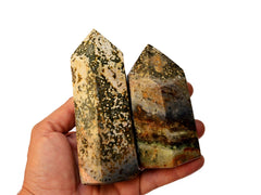 Two chunky sea jasper prism stones on hand with white background