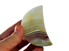 One pink banded onyx moon shapped mineral 60mm on hand with white background