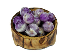 Several amethyst crystal spheres 25mm - 40mm inside a wood bowl on white background