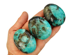 Three amazonite palm stones 40mm-50mm on hand with white background