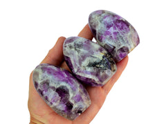 Three amethyst quartz free forms 70mm-100mm on hand with white background