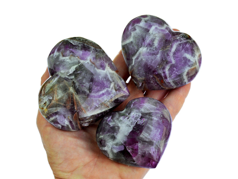 Three amethyst heart crystals 50mm-80mm on hand with white background