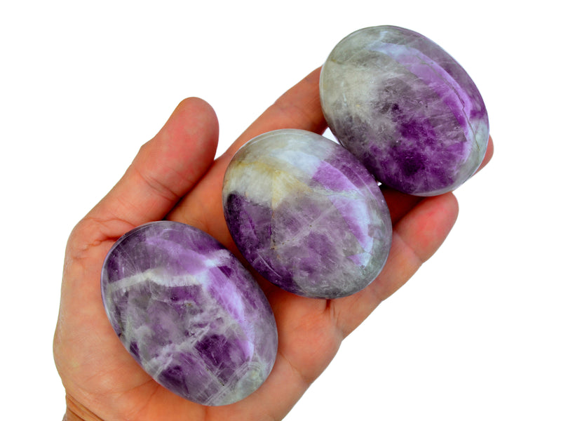 Three amethyst palmstones 50mm on hand with white background