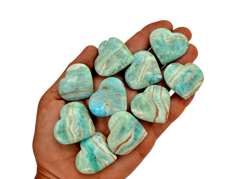Ten blue aragonite hearts 30mm-35mm on hand with white background