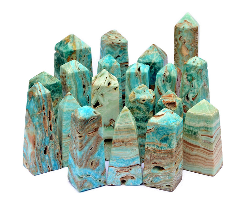 Several blue aragonite crbackgroundystal obelisks different sizes on white background