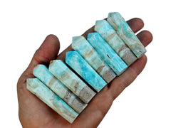 Eight  blue aragonite faceted crystal points 45mm-65mm on hand with white background