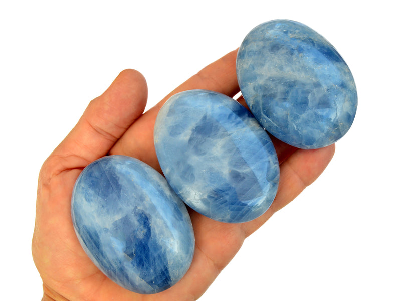 Three blue calcite palm stone crystals 55mm on hand with white background