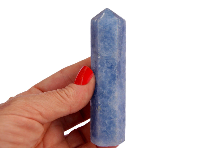 One blue calcite crystal tower 90mm on hand with white background