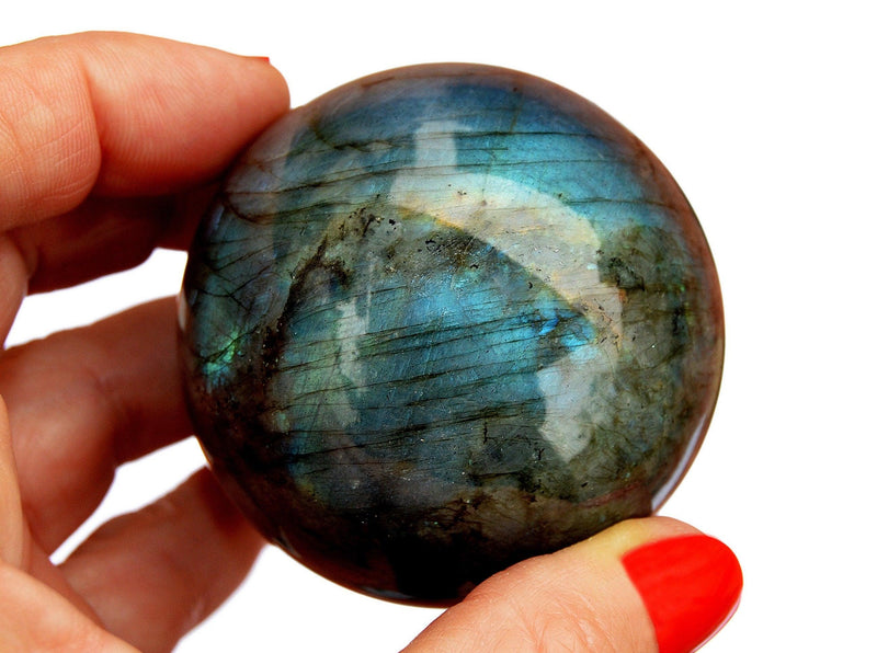 One blue labradorite sphere 60mm on hand with white background