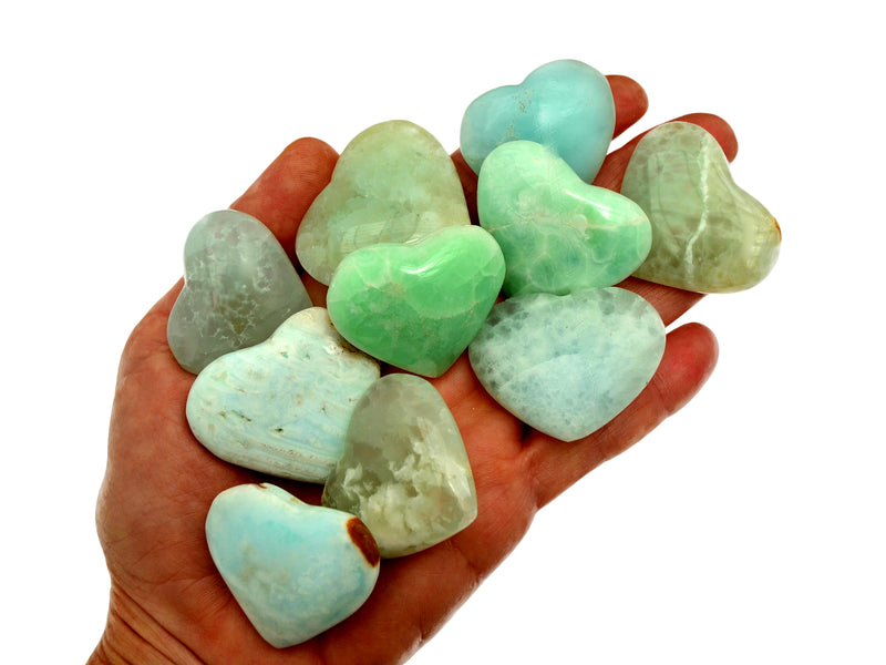 Ten caribbean calcite small hearts on hand with white background