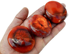 Three carnelian palm stones 40mm-70mm on hand with white background