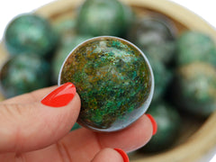 Green chrysocolla sphere crystal 35mm on hand with white background