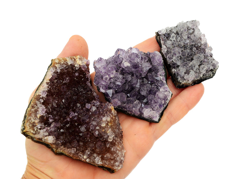 Three druzy amethyst crystals 50mm-100mm on hand with white background