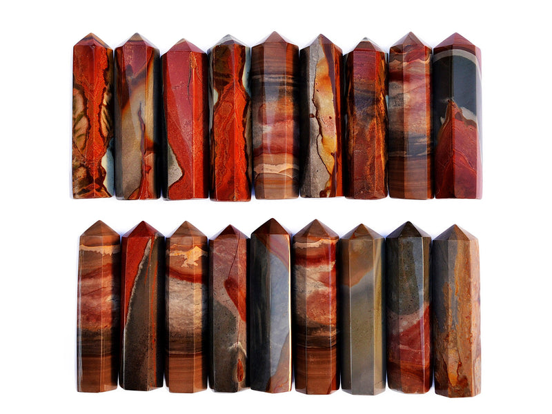 Several polychrome jasper faceted crystal points 90mm forming two lines on white background