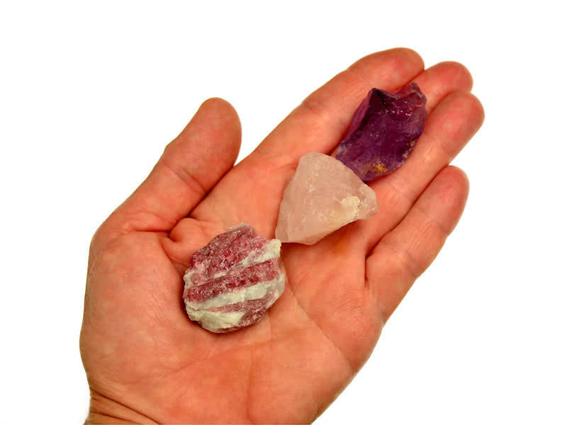 Raw pink tourmaline in matrix, rose quartz and amethyst 30mm-40mm on hand with white background