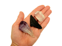 One raw amethyst point, black kyanite and clear quartz point 30mm-40mm on hand with white background