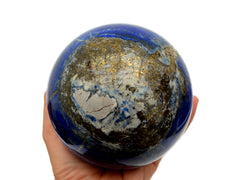 Extra large lapis lazuli sphere 105mm on hand with white background