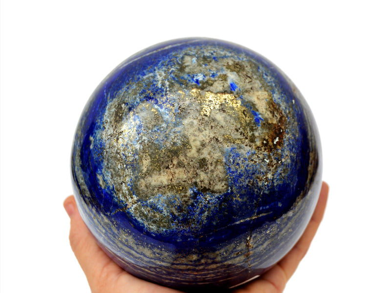 Extra large lapis lazuli sphere 100mm on hand with white background