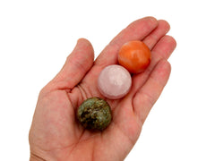 Carnelian, rose quartz and chrysocolla spheres 30mm on hand with white background