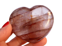 One large fire quartz heart crystal 67mm on hand with white background