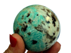 Green amazonite sphere 60mm on hand with white background