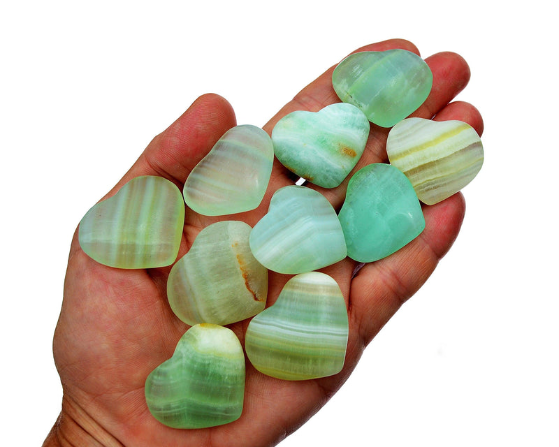 Ten green pistachio calcite crystal hearts 35mm-40mm on hand with white background