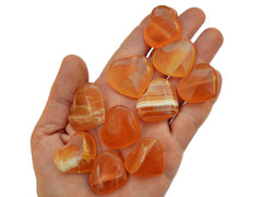 Ten honey calcite crystal hearts small 25mm-30mm on hand with white background