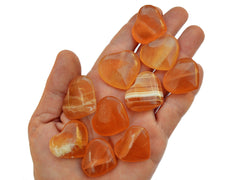 Ten honey calcite crystal hearts small 25mm-30mm on hand with white background