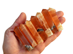 Seven honey calcite faceted crystal points 55mm-60mm on hand with white background