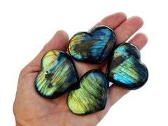 Four blue and green labradorite heart crystals 45mm on hand with white background