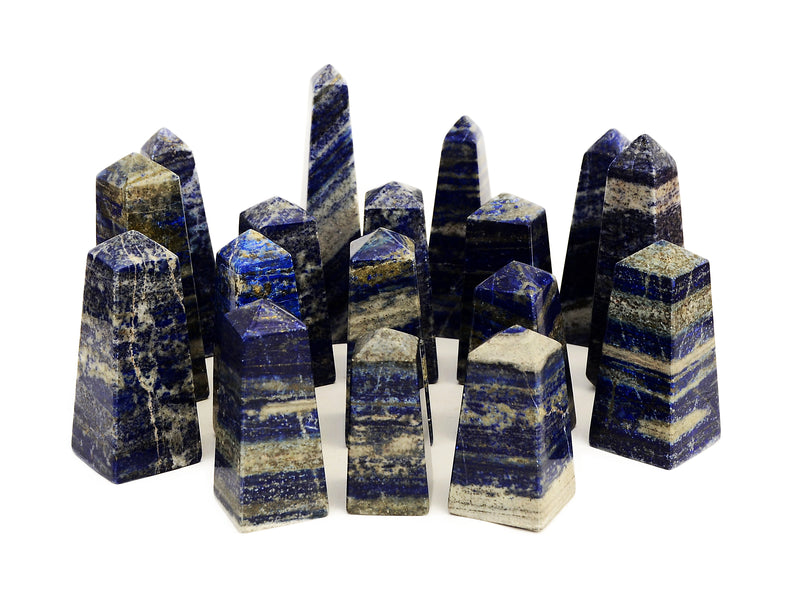 Several blue lapis lazuli obelisks in diferrent sizes on white background