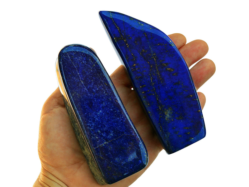Two blue lapis lazuli free form slab crystals 90mm-130mm on hand with white background