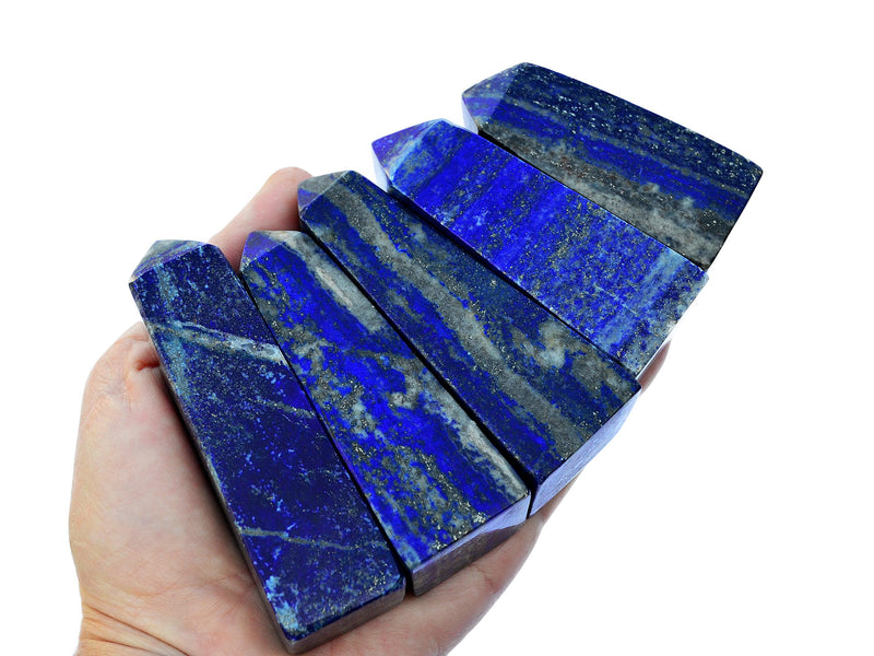 Five lapis lazuli tower crystals 60mm-100mm on hand with white background