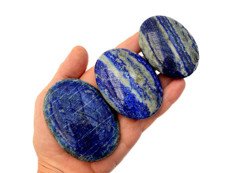 Three lapis lazuli palm stones 45mm-75mm on hand with white backround