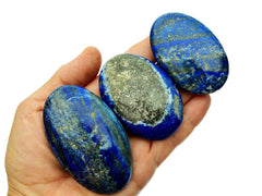Three lapis lazuli palm stones 45mm-80mm on hand with white background