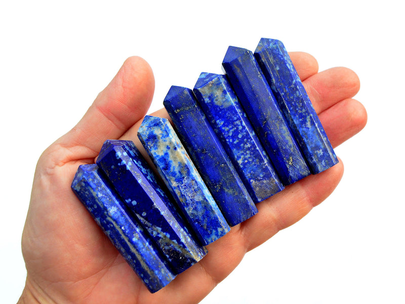 Seven lapis lazuli tower points 55mm-65mm on hand with white background