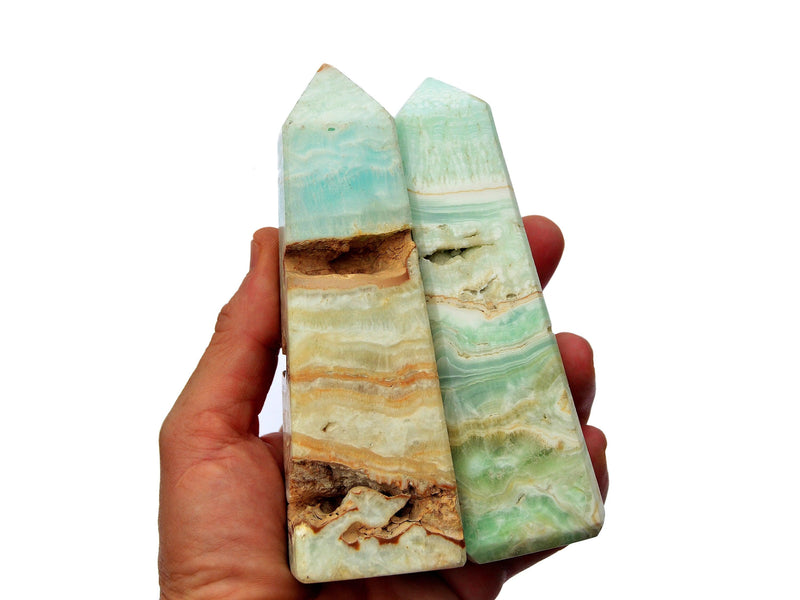 Two large caribbean calcite towers on hand with white background