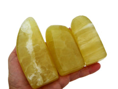 Three lemon calcite free form minerals 80mm-90mm on hand with white background