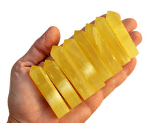 Eight lemon calcite crystal points 50mm-65mm on hand with white background