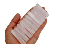 Ten mangano calcite prism crystals 55mm on hand with white background