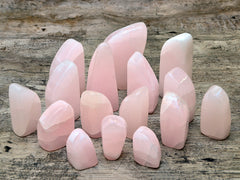 Some pink mangano calcite free forms 50mm-100mm on wood table